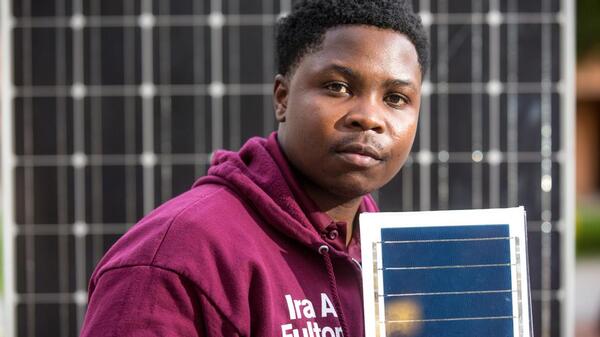 Picture of Ngoni Mugwisi holding a solar panel